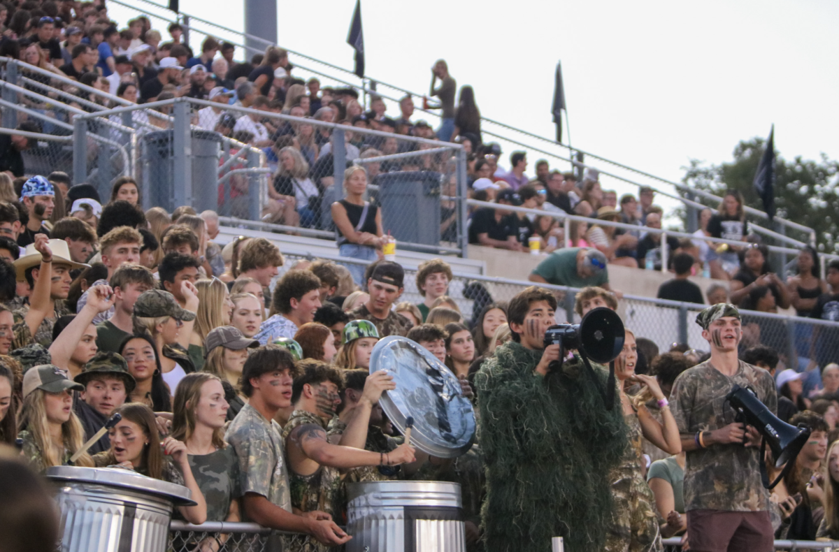 Students fill the student section of the bleachers at Monroe Stadium for a varsity football game. 